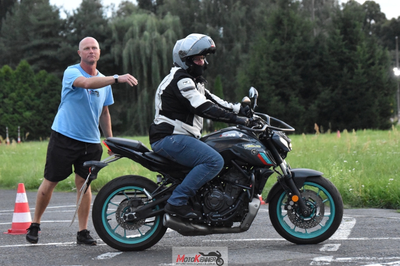 Instruktor wskazuje kierunek jazdy kursantowi na motocyklu podczas szkolenia na prawo jazdy A2.