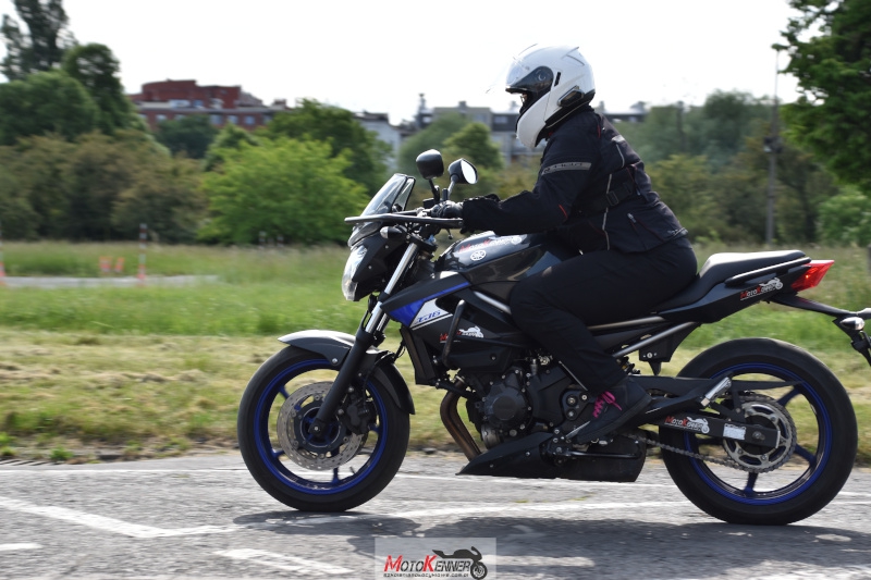 Kursantka praktykująca jazdę na motocyklu średniej klasy, zgodnym z kategorią prawa jazdy A2.